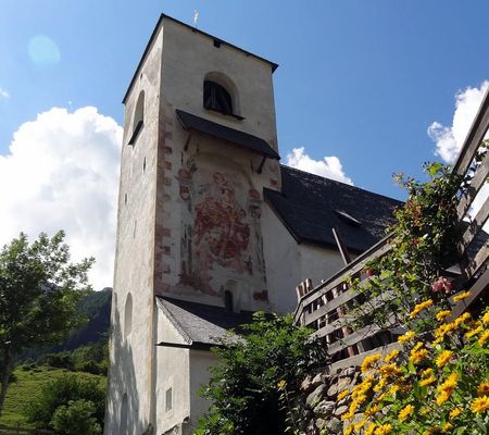 Das St. Nikolaus-Kirchlein mit seinem mächtigen Turm und dem St. Christophorus-Fresko an der Nordseite des Turms.